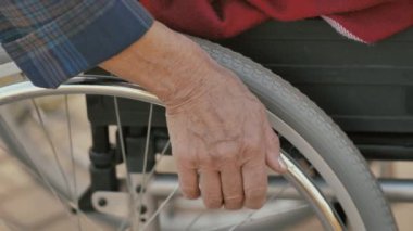 Kadın eli tekerlekli sandalyenin direksiyonunu alır.