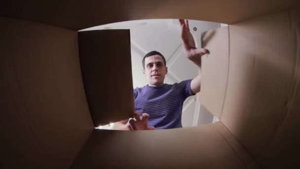 Nieszczęśliwy człowiek otwierający pudełko tekturowe — Wideo stockowe