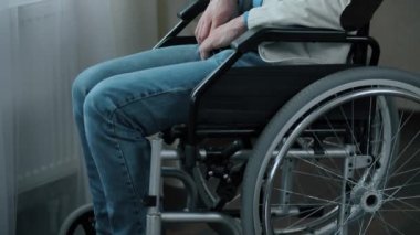 Odada tekerlekli sandalyede bir adam var.