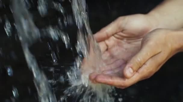 Víz ömlik az ember kezében — Stock videók