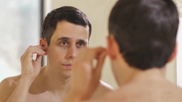 L'homme nettoie ses oreilles dans la salle de bain — Video