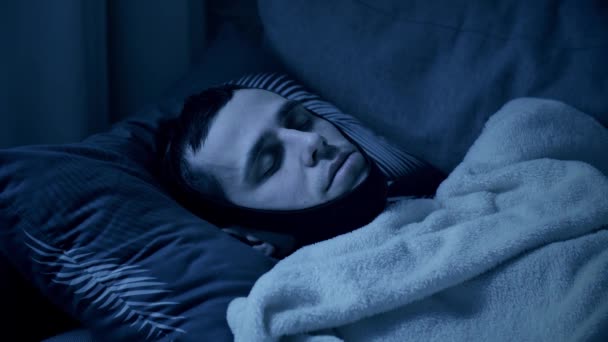 Мужчина спит с повязкой от храпа — стоковое видео