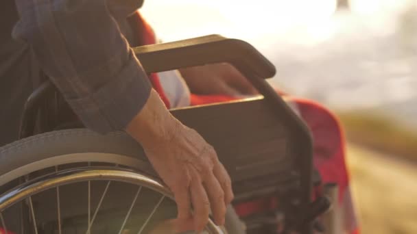 Main prend le volant d'un fauteuil roulant — Video