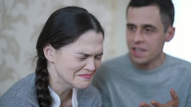 Een man schreeuwt tegen een vrouw die huilt. — Stockvideo
