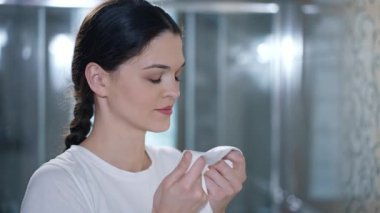 Kadın temiz gömleği kokluyor.