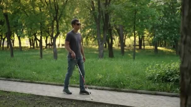 Hombre ciego camina con un bastón en el parque — Vídeos de Stock