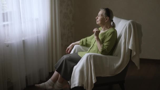 Стара жінка сидить на кріслі — стокове відео