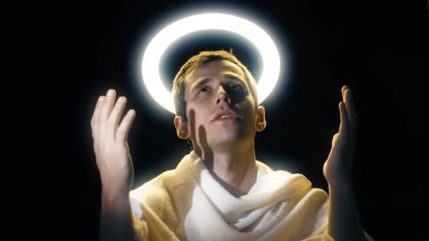 Holy man with a halo above his head praying — Stock Video