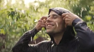 Yağmur altında neşeli genç adam