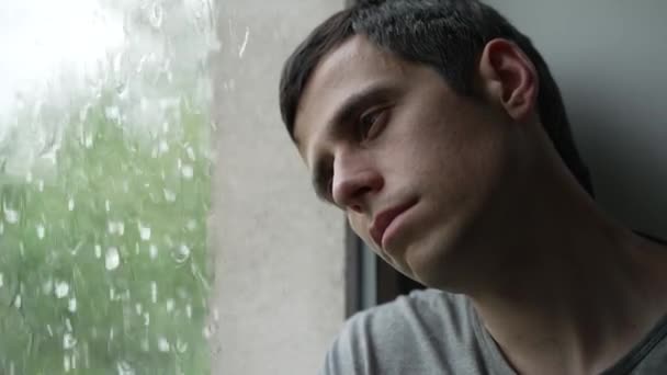 Triste hombre mira fuera de la ventana — Vídeos de Stock