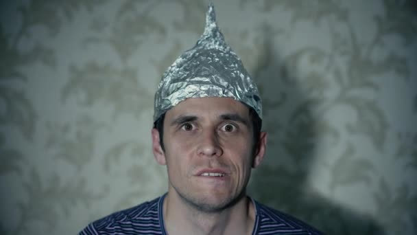 Άνθρωπος με καπέλο από αλουμινόχαρτο βλέποντας τηλεόραση — Αρχείο Βίντεο