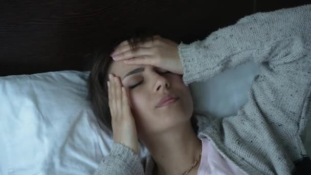 Женщина с головной болью в постели — стоковое видео