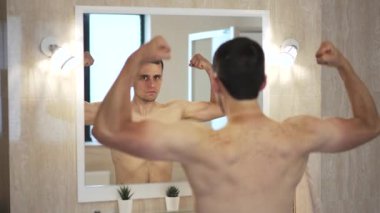 Adam aynadaki kaslara bakıyor.