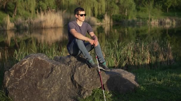 Pria buta dengan tongkat duduk di atas batu — Stok Video
