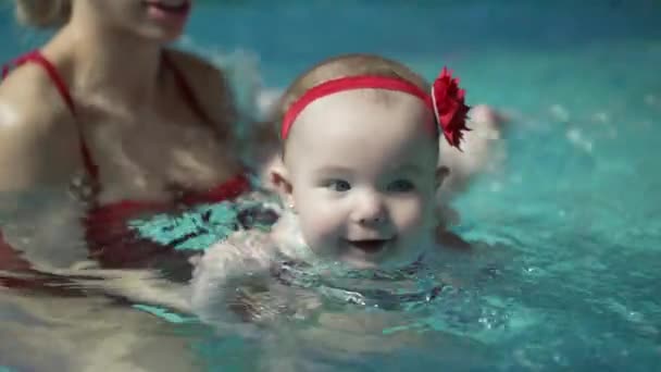 Baby onderwijs om te zwemmen in het zwembad — Stockvideo