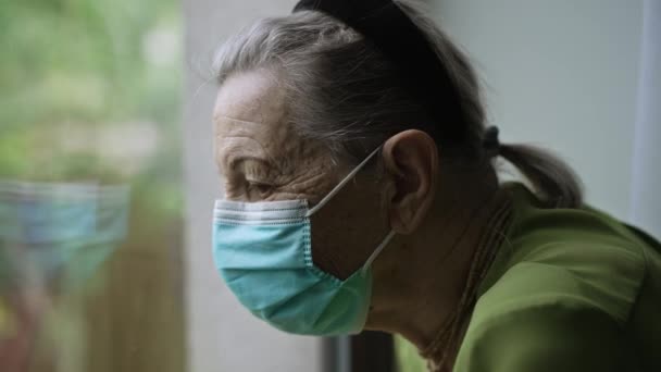 Stará žena se dívá z okna — Stock video