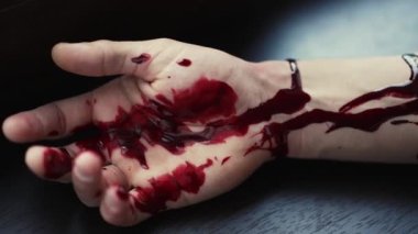 Yerde kanlı bir adam var.