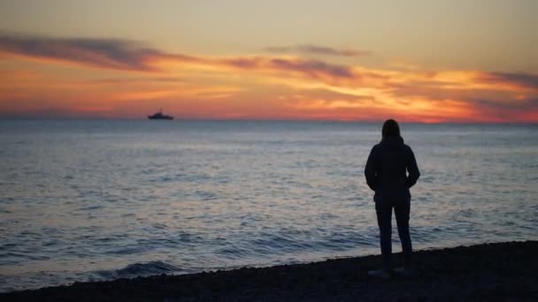 Woman looks at the sea sunset – Stock-video