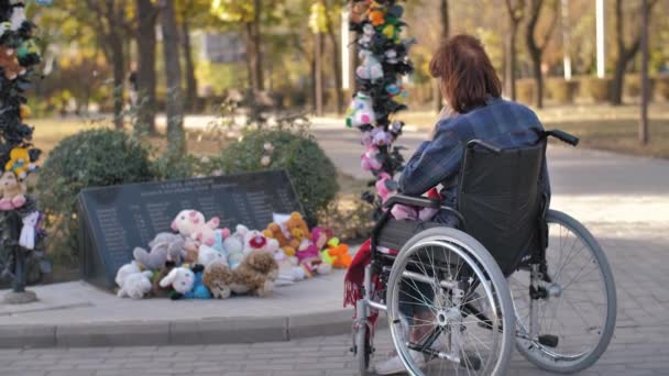 Kobieta na wózku inwalidzkim w pobliżu miejsca pamięci zaginionych dzieci — Wideo stockowe