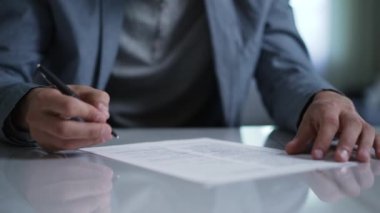 Bir adam bir belge imzalıyor.