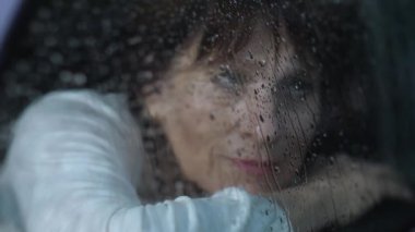 Üzgün kadın pencereden dışarı bakar