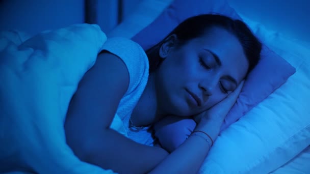 Женщина спит по ночам в постели — стоковое видео