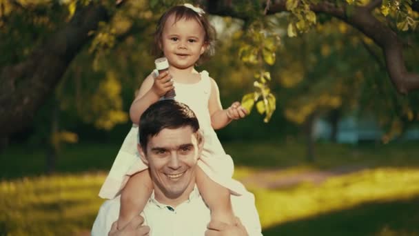 Little girl sitting on daddys shoulders — Stock Video