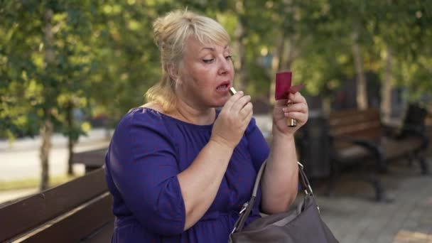 Femme dodue peint ses lèvres dans la rue — Video