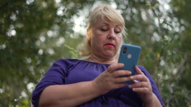뚱뚱 한 여자 가 도시에서 스마트폰을 사용하는 모습 — 비디오