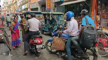 Dar, dar bir Hint yolu yayalar, motosikletler ve arabalarla dolu..