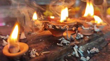 Işık tutanlar ve tapınak lambasının içinde yüzen küçük pamuklar sunarlar.