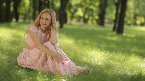 Sorrindo mulher romântica sentada na grama — Vídeo de Stock