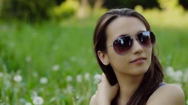 Junge Frau mit Sonnenbrille preens — Stockvideo