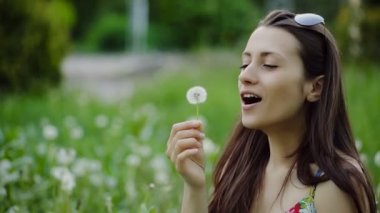 Çekici kız karahindiba üzerinde üfleme