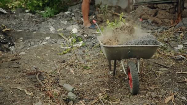 Man verzamelen bouwmaterialen in een kar — Stockvideo