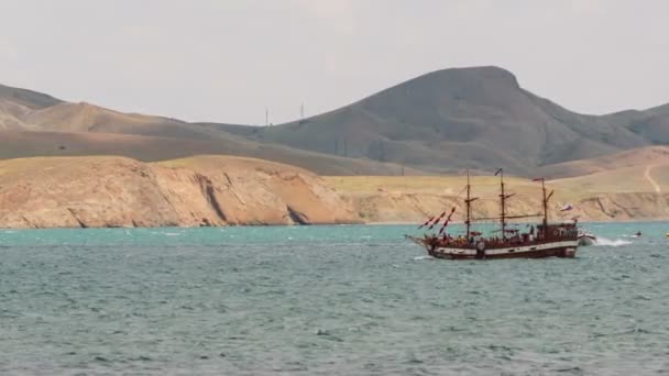 Schiff mit Touristen schwimmt in der Nähe der Berge — Stockvideo