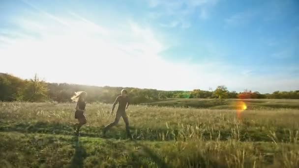 Casal feliz correndo no campo — Vídeo de Stock