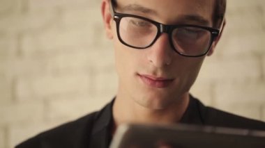 Tablet bilgisayarda çalışan genç çekici adam