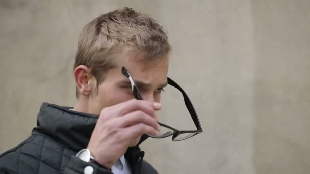 Junger attraktiver Mann setzt eine Brille auf — Stockvideo