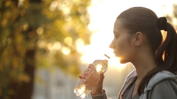 Mujer bebiendo agua contra los rayos de sol — Vídeos de Stock