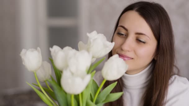 Vrouw ziet er op tulpen — Stockvideo