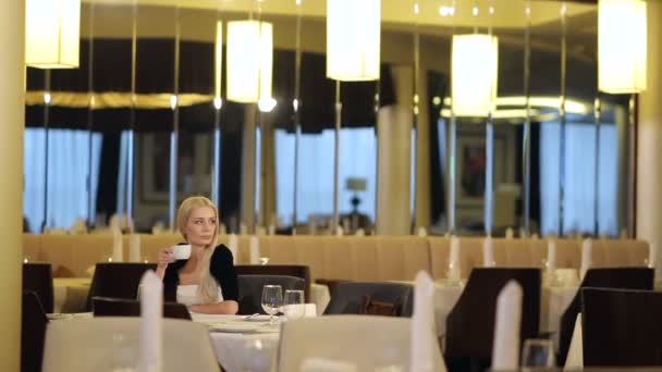 Attraktive Frau trinkt Kaffee im Restaurant — Stockvideo