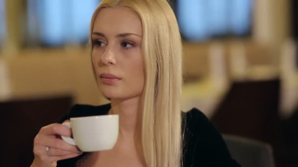 Attraktiv kvinna dricker kaffe på restaurang — Stockvideo