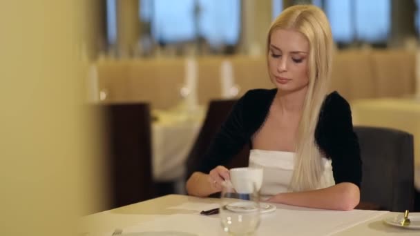 Attraktive Frau trinkt Kaffee im Restaurant — Stockvideo