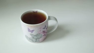 El alır ve çay koyar