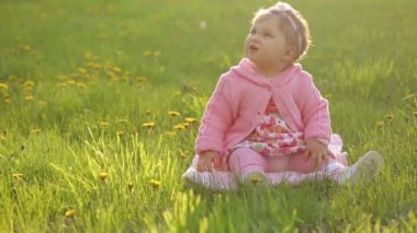 Yeşil çimenlerin üzerinde oturan bebek portresi