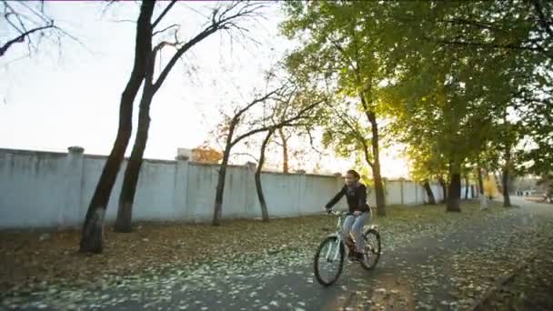 Gladlynt kvinna Rider en cykel under hösten Park — Stockvideo