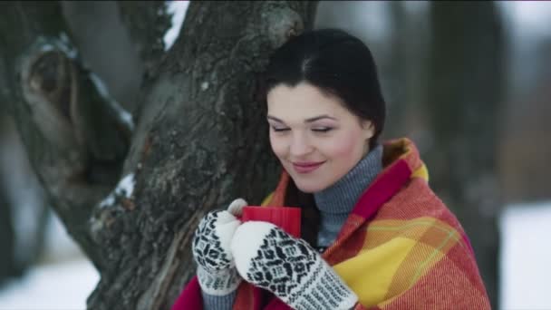 Γυναίκα που καλύπτεται με ένα φλιτζάνι τσάι, στο πάρκο του χειμώνα — Αρχείο Βίντεο