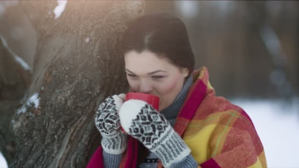 Mujer cubierta con una taza de té en el parque de invierno — Vídeos de Stock