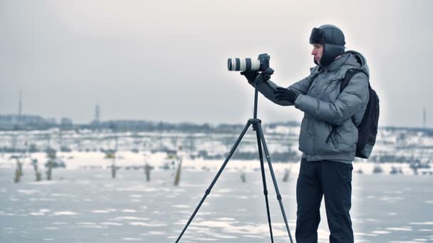 Фотограф с треногой зимой — стоковое видео